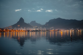 Evening city lights twinkling beneath the peaceful mountain backdrop