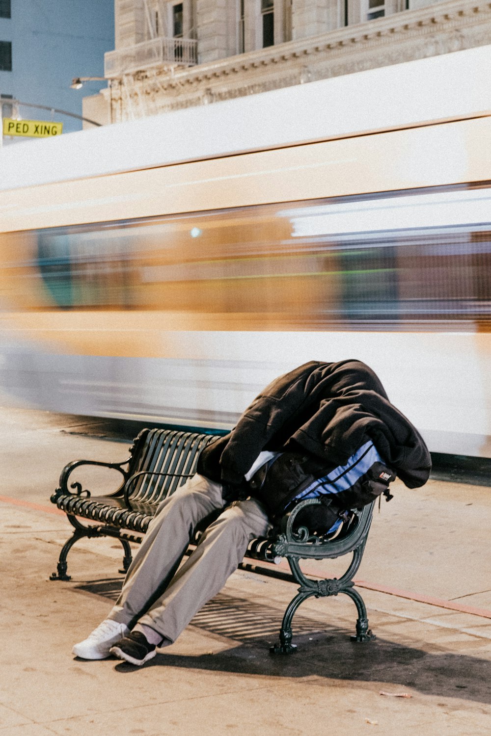 person sleeping on black steel bench