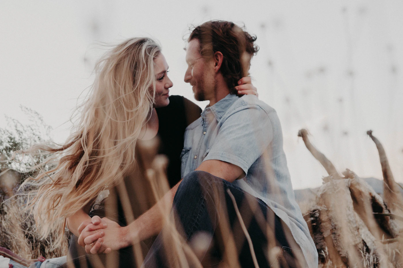 Couple sitting closely together and looking at each other outdoors