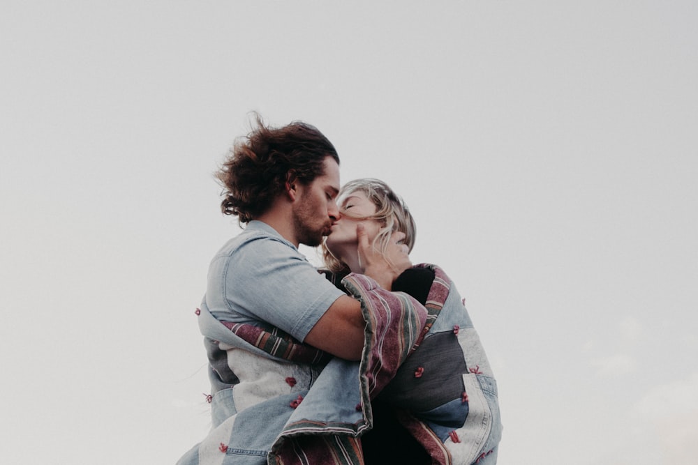 fotografia ad angolo basso di uomo e donna che si baciano