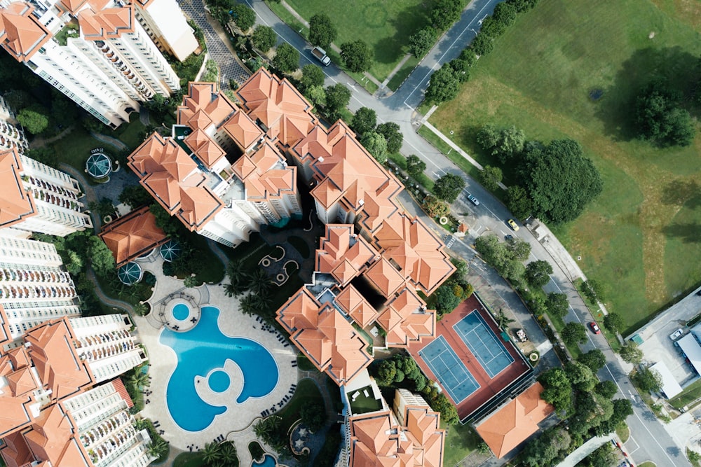 top view photography of brown-and-white buildings beside swimming pool
