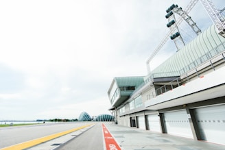 A dusk view of a modern race track with sleek pit buildings and grandstands.