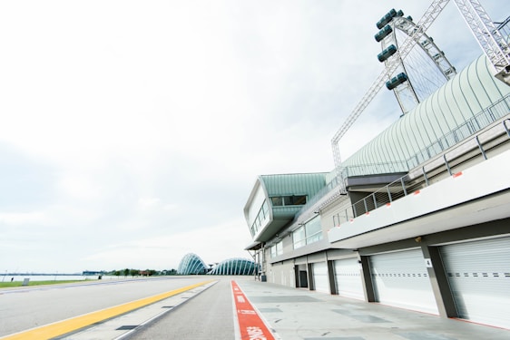 Exterior view of Interlagos Hub store with racing track curves in the background under a clear sky.