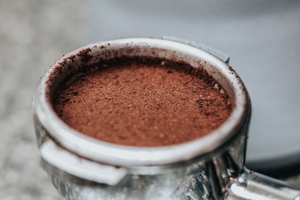 selective focus photography of coffee ground in round container