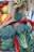 A variety of fresh produce including bananas, lemons, tomatoes, carrots, broccoli, red chili peppers, green onions, and a wooden spoon with a green powder.