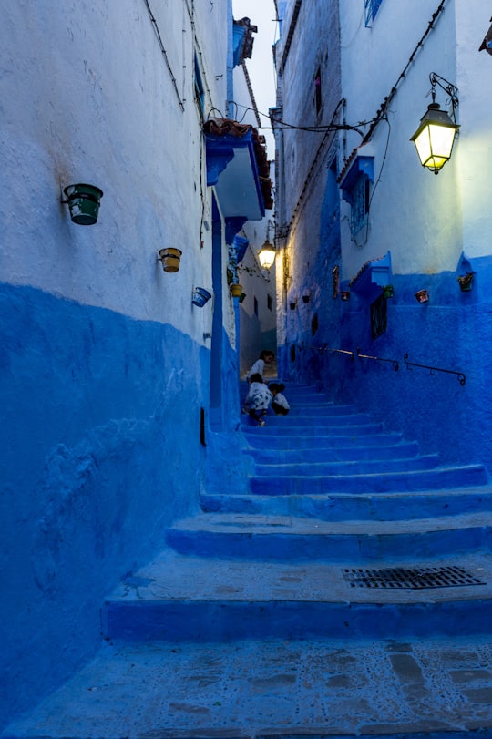 children climbing up blue stairs in Chefchaouen Morocco