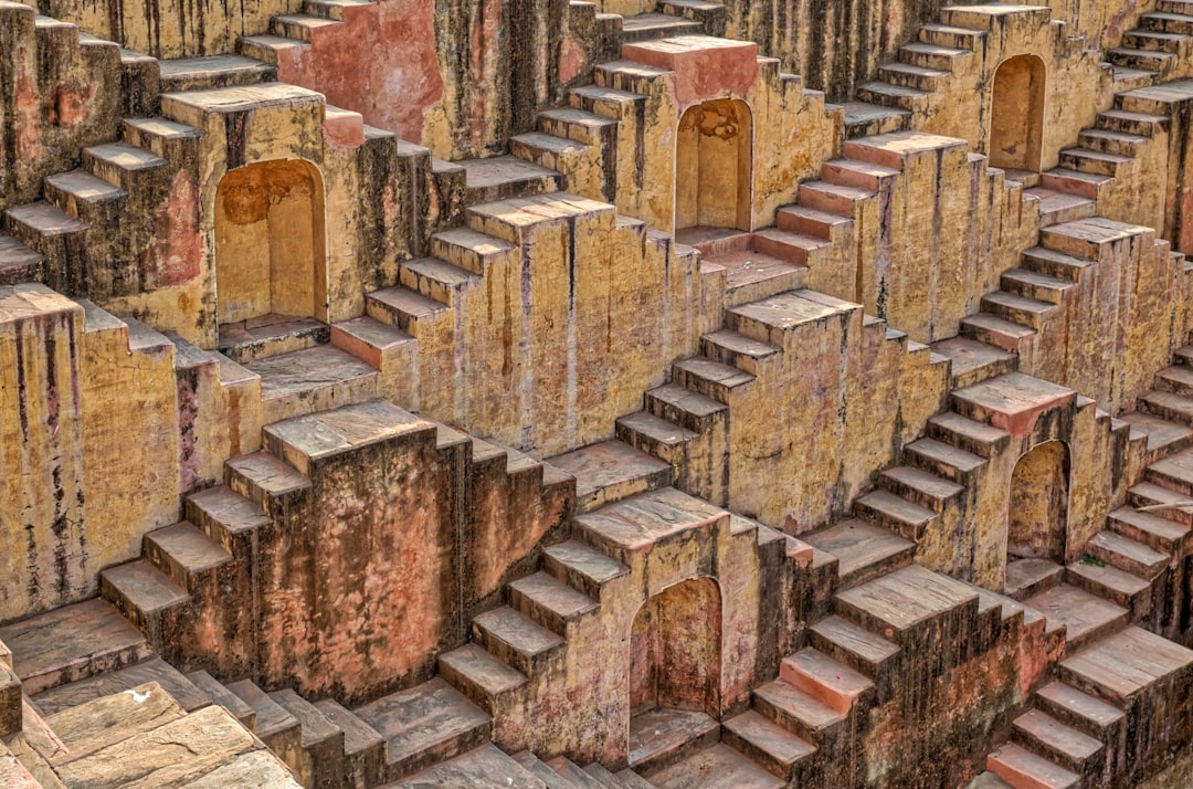 a very large group of stone structures in a park, Detail of a stepwell in India.