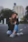 woman smiling while sitting on road with hand resting on top of her knee