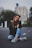 woman smiling while sitting on road with hand resting on top of her knee