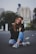 woman smiling while sitting on road with hand resting on top of her knee
