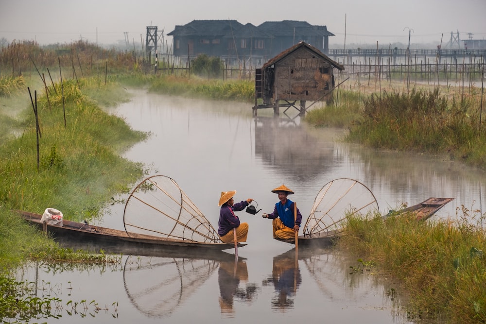 two men riding boats on water