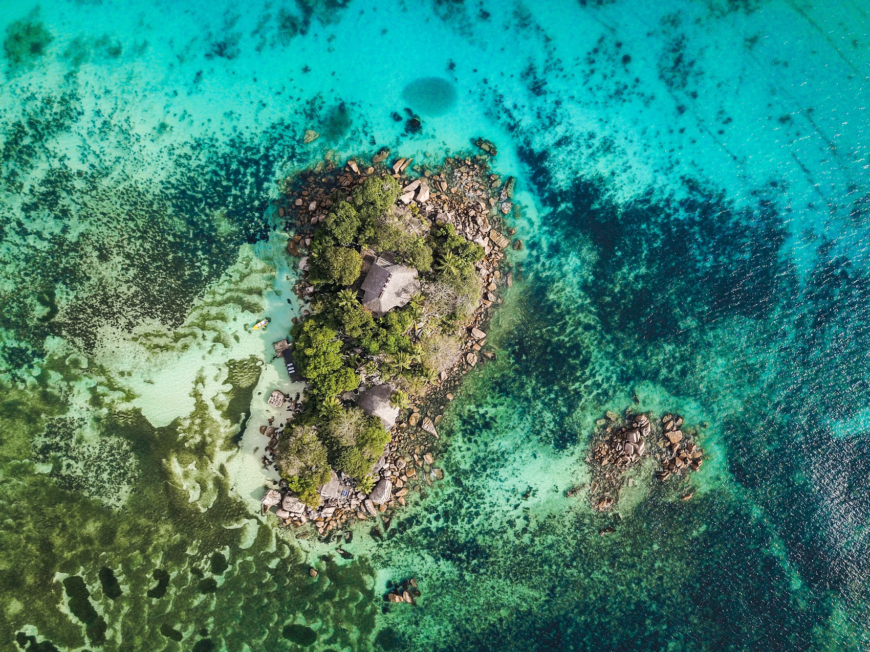 A small green island and reef beside Praslin seen from above