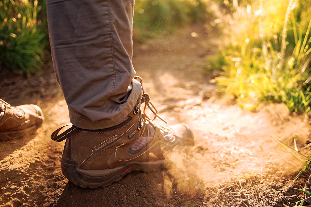 personne portant une paire de baskets marron