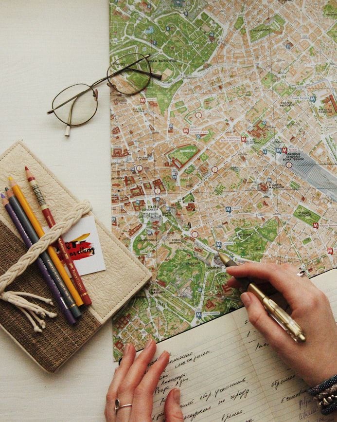 Landkarte, Brille und ein Reisetagebuch mit Notizen – Reiseerinnerungen festhalten