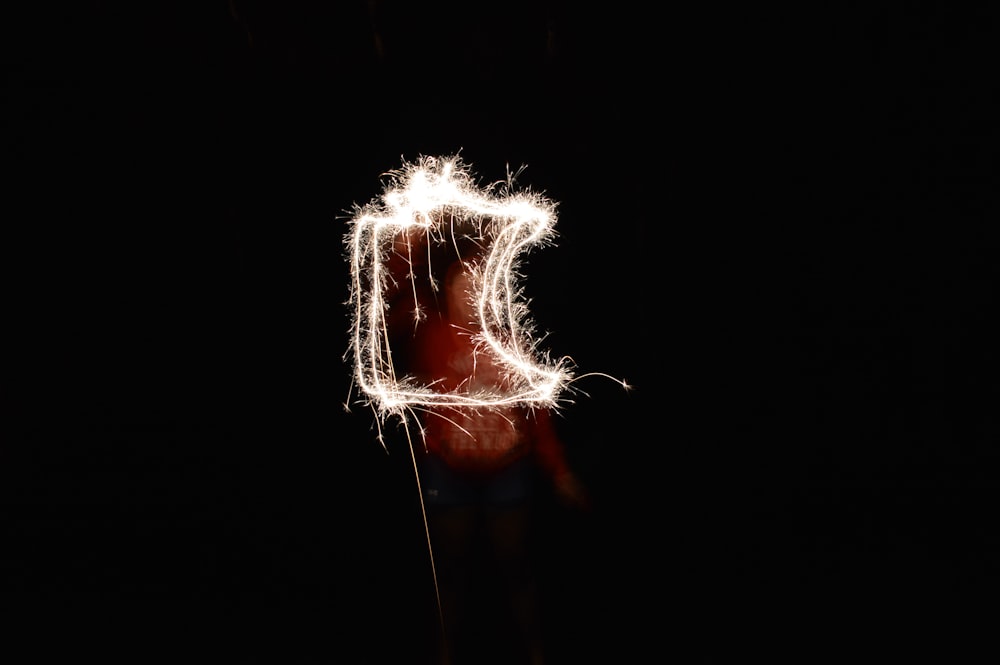 steel wool photography of man holding fireworks
