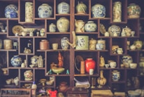 Close-up of decorative ceramic vases on a wooden shelf.