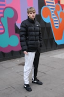 A vibrant streetwear outfit displayed on a city sidewalk with graffiti walls.