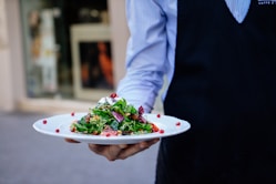 person holding a plate of salad