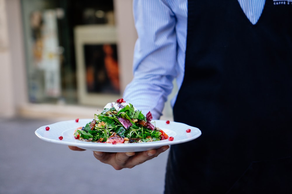 person holding a plate of salad