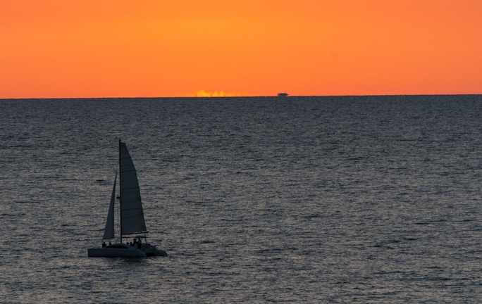 A sailboat glowing orange under the early morning sun near Tampa Bay.