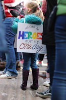 girl carrying white signage board