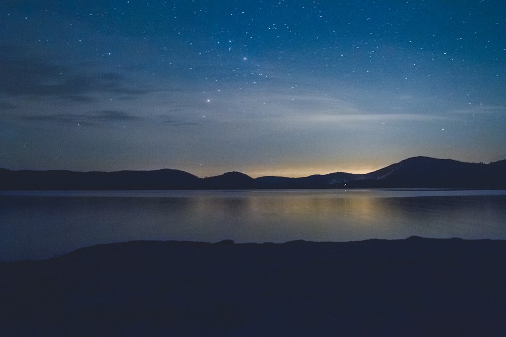 silhouette di montagna di fronte allo specchio d'acqua