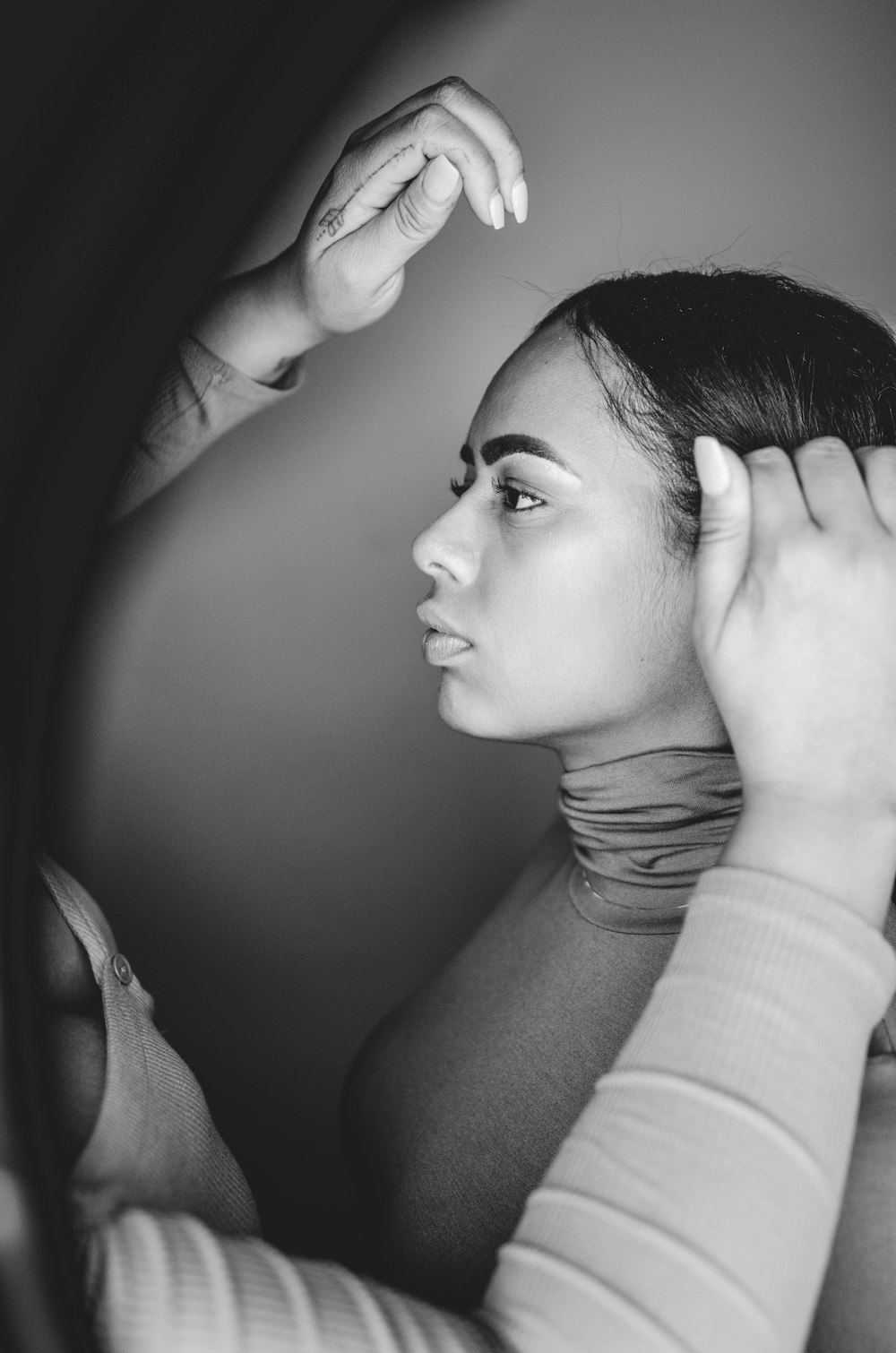 grayscale photo of person holding woman's hair