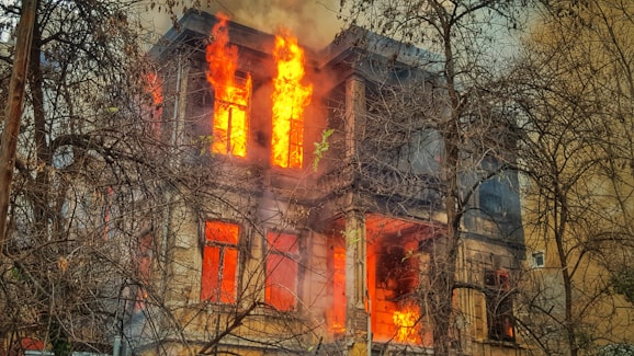 photo of burning house near trees