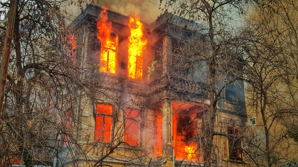 Photo d’une maison en feu près d’arbres