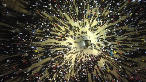 Crowd gathered around neon-lit cars with synth pop music playing.