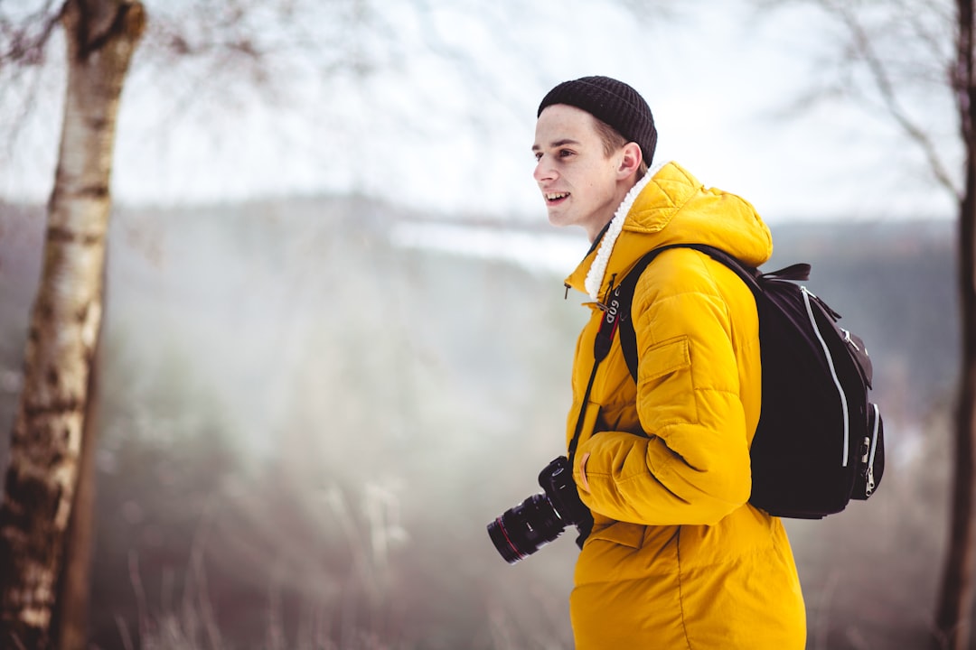 man wearing jacket and camera during daytime