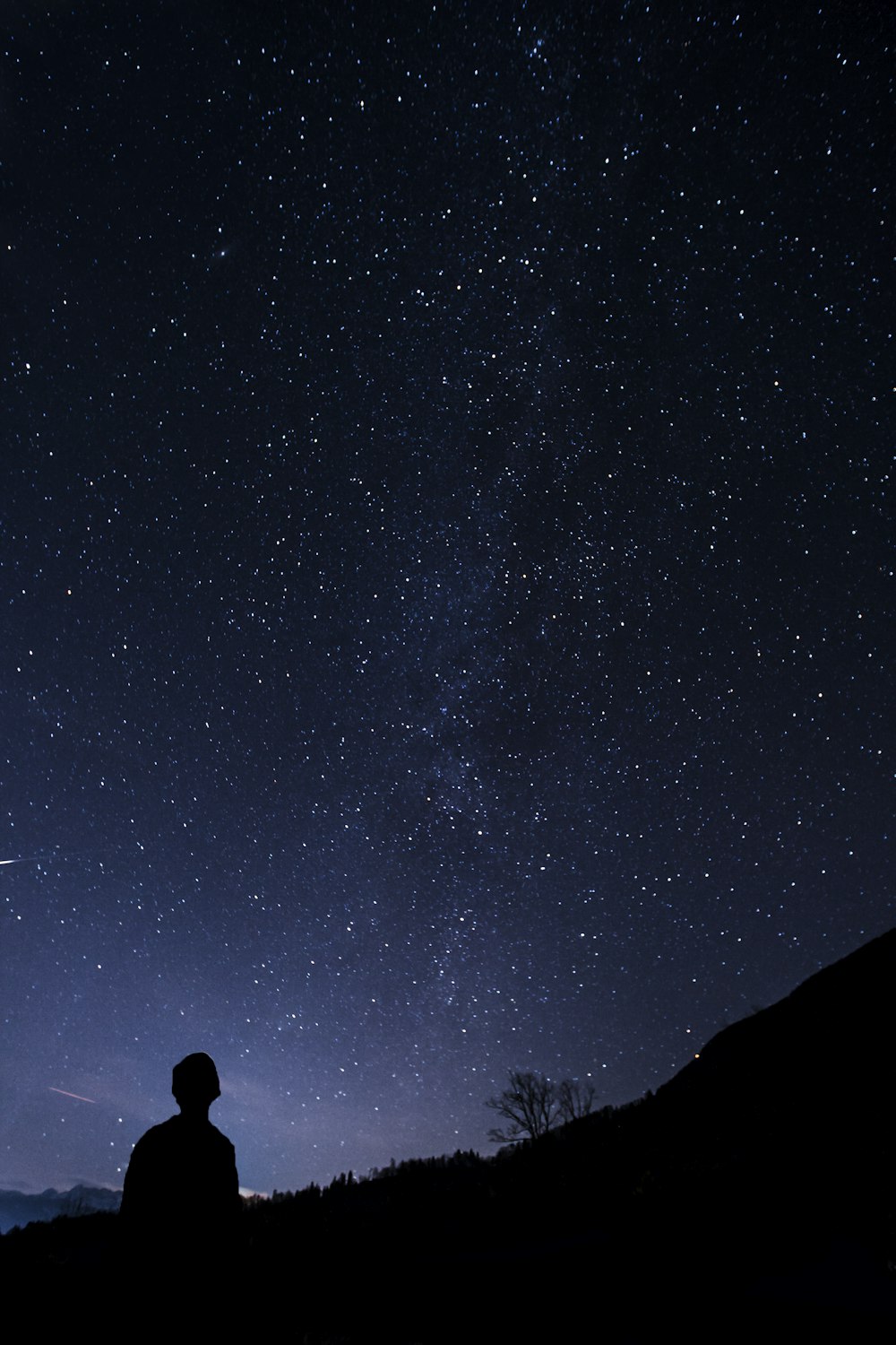 silhouette of man looking at milky way