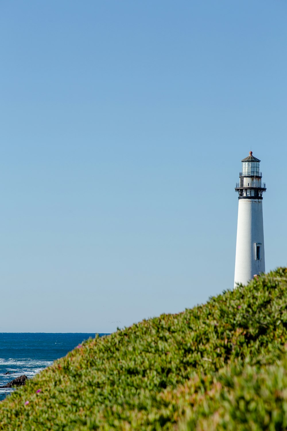 Phare au bord d’un plan d’eau pendant la journée