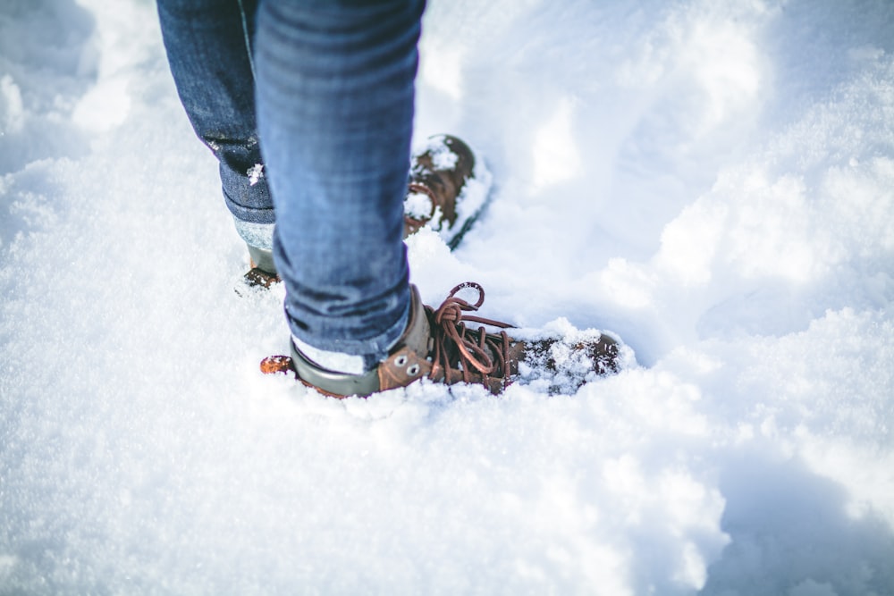 Person mit braunen Schuhen auf Schnee