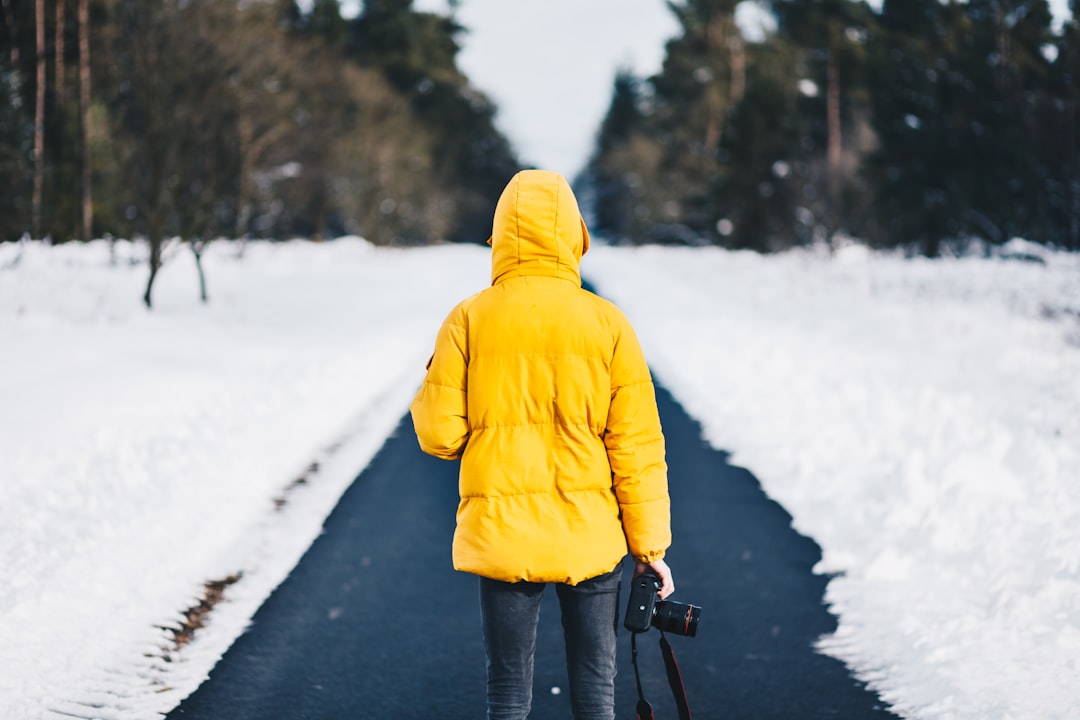 person on yellow jacket standing between snow floors