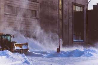 Close-up of a snowplow clearing thick snow from a residential street in Edmonton.