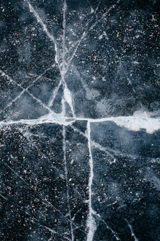 a black and white photo of a cross made of ice