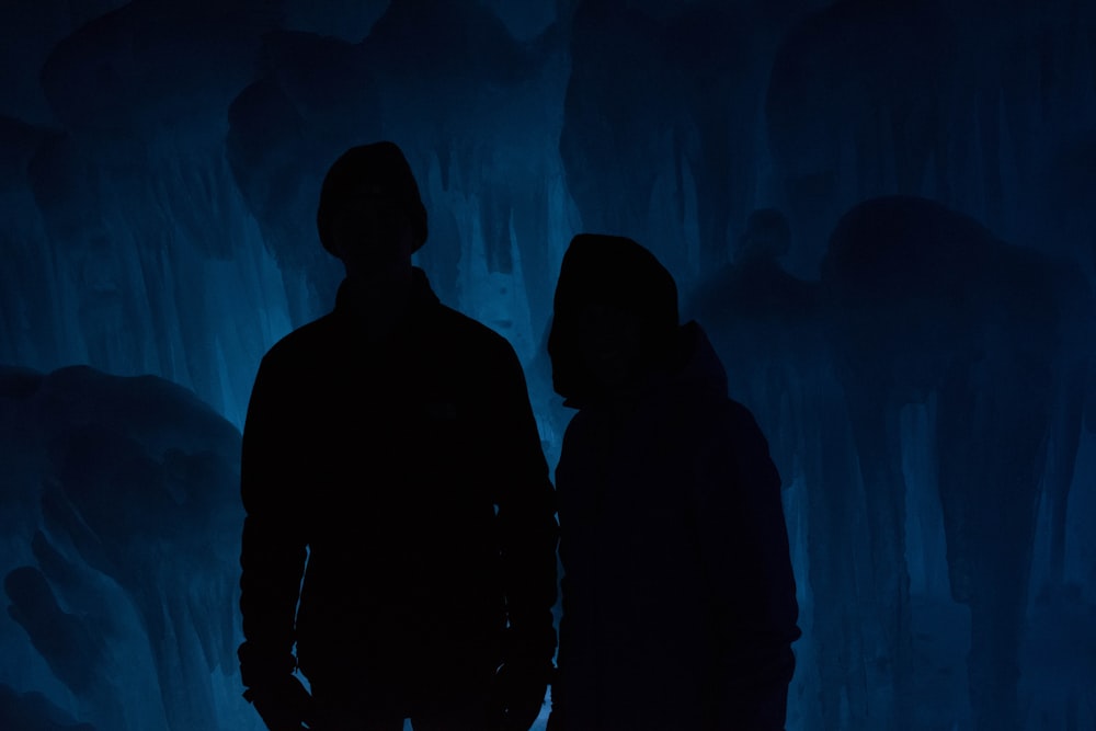 silhouette of man and woman inside cave