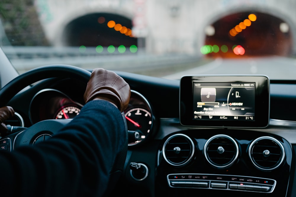 person inside vehicle holding steering wheel