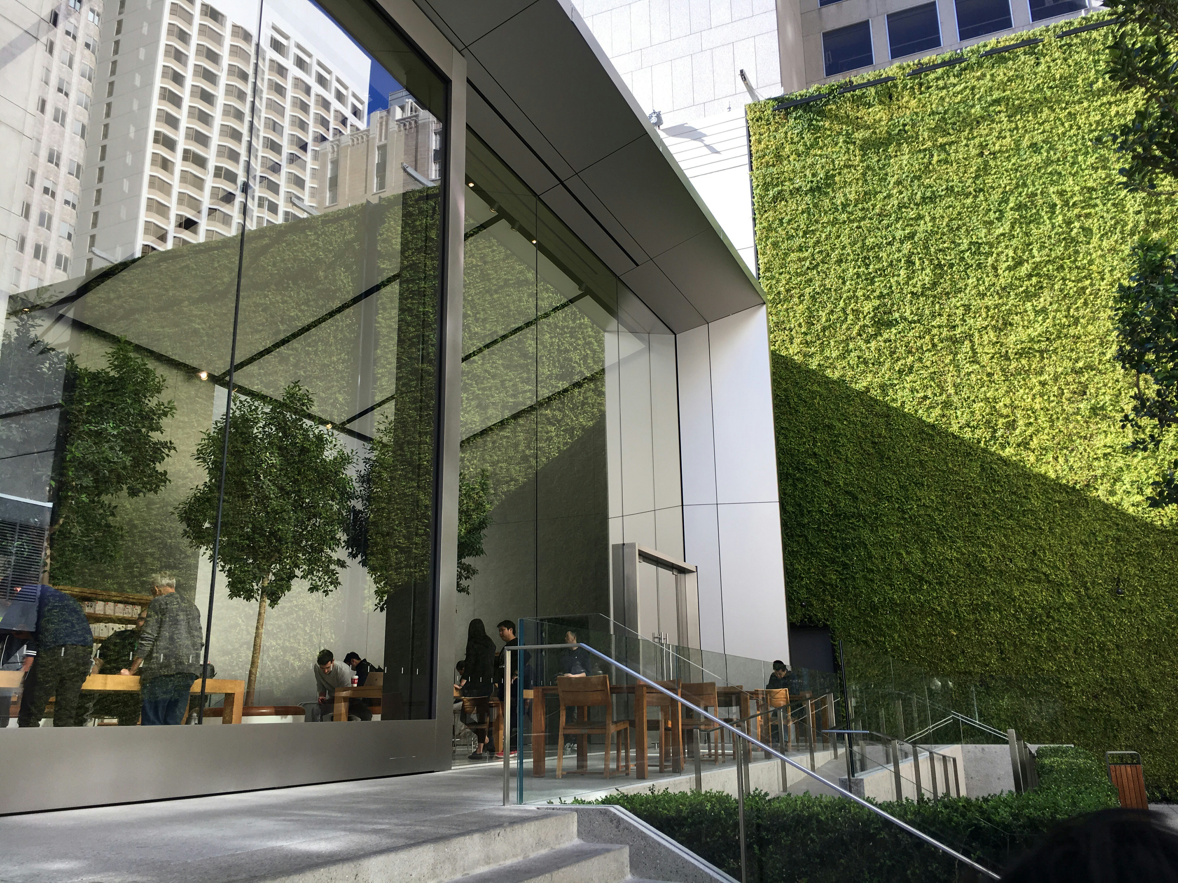 Modern green building with solar panels and living wall, bright natural daylight, sustainable architecture