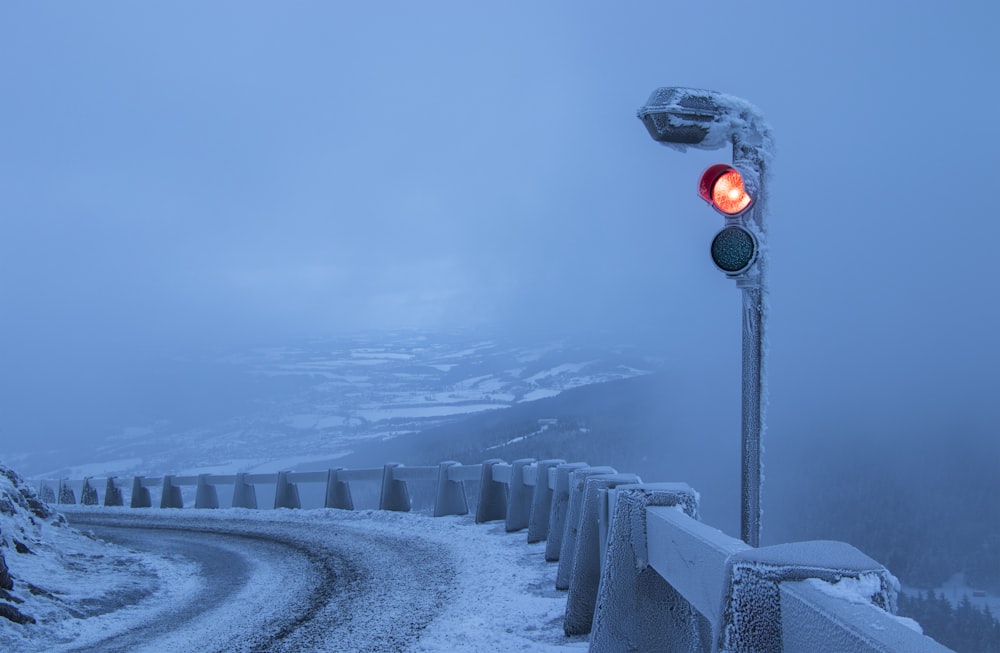 traffic light beside gray metal fence