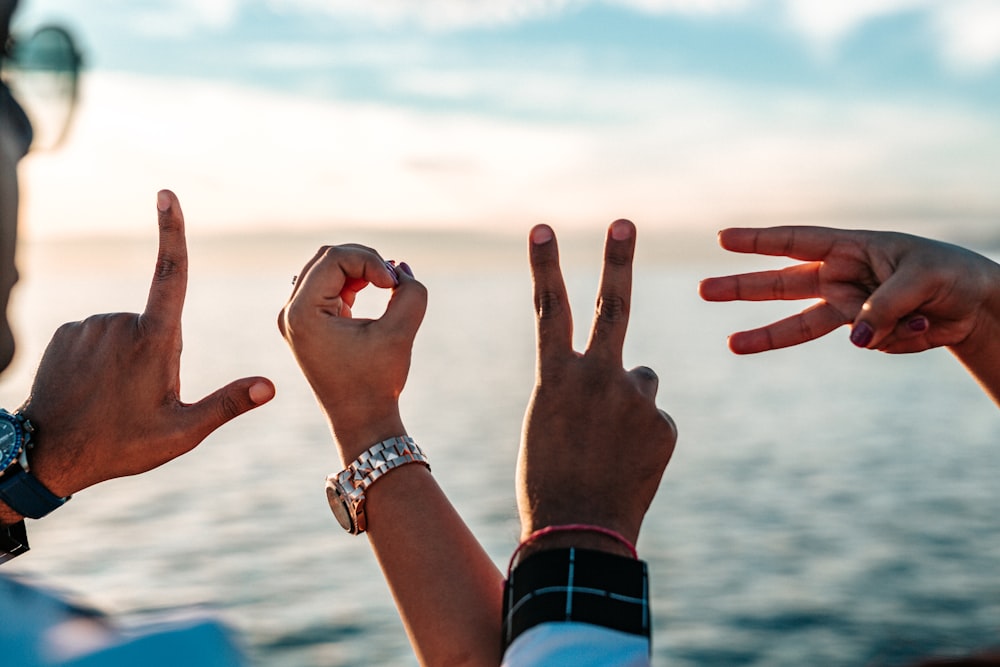 two persons forming love fingers