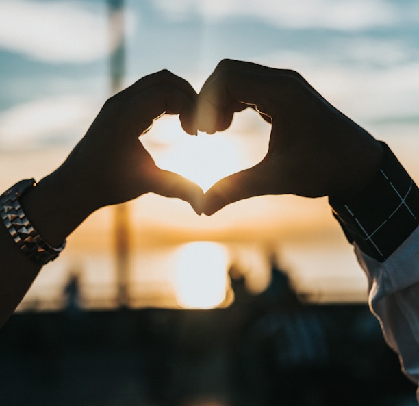 person forming heart with their hands