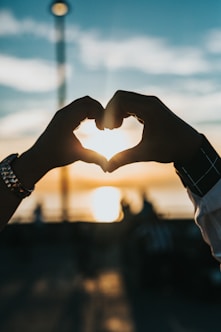 person forming heart with their hands