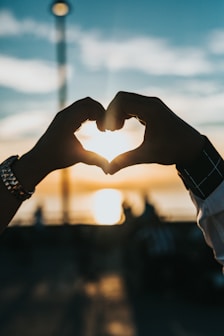couple in love forming heart with their hands