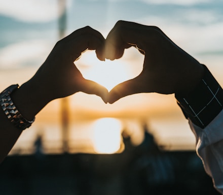 person forming heart with their hands