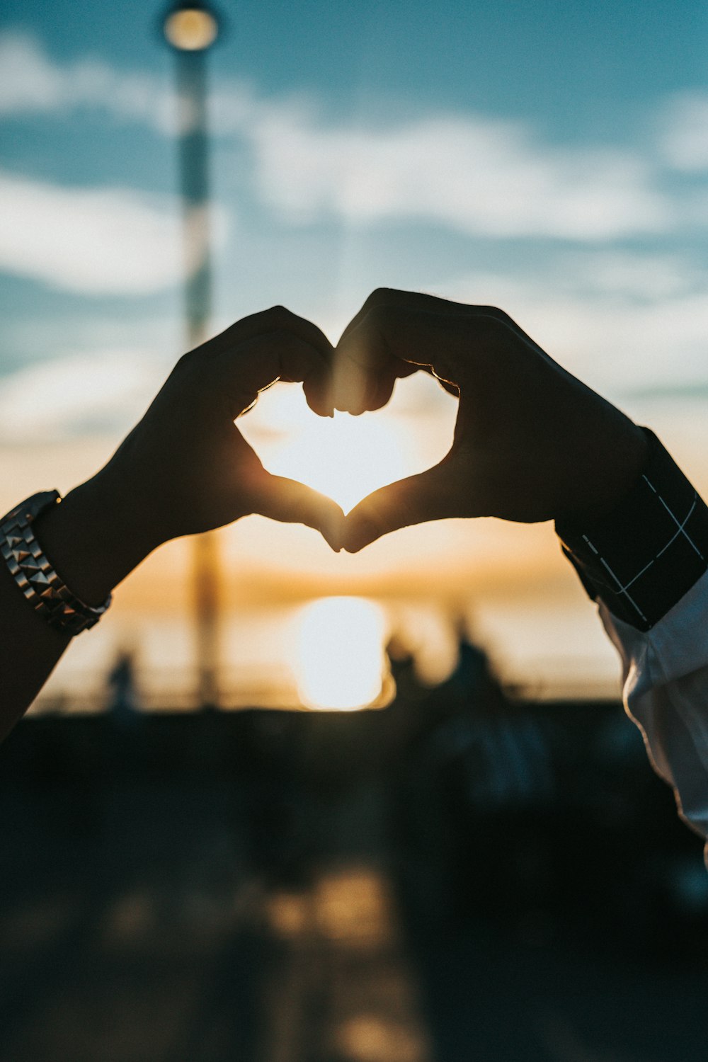 person forming heart with their hands