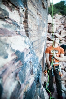 An instructor demonstrating anchor building techniques on natural rock.