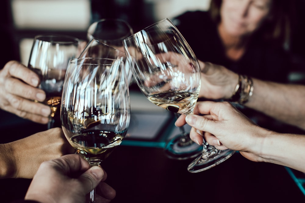 group of people holding footed glasses