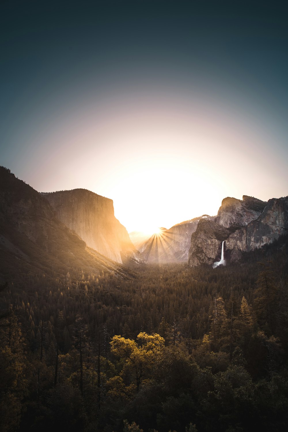 gray mountain surrounded with trees during sunrise